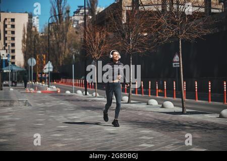 Heureuse femme athlétique qui fait du jogging le matin Banque D'Images