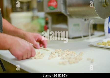 PIACENZA, ITALIE - 17 juillet 2021: Femme faisant des pisarei, pâtes commerciales, pâtes fraîches extrudées, faites de chapelure, eau, blé tendre de type quatre 00, Banque D'Images