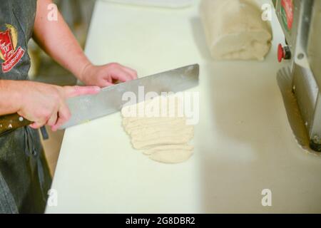 PIACENZA, ITALIE - 17 juillet 2021: Femme faisant des pisarei, pâtes commerciales, pâtes fraîches extrudées, faites de chapelure, eau, blé tendre de type quatre 00, Banque D'Images