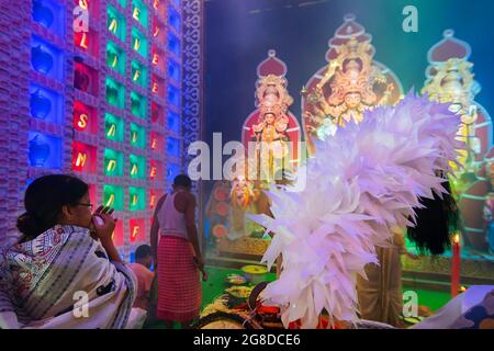 Howrah, Bengale-Occidental, Inde - 5 octobre 2019 : femme hindoue bengali jouant shankha, conch shell, pendant sondhya aarti. Dhaaks et kansor ghonta sont p Banque D'Images