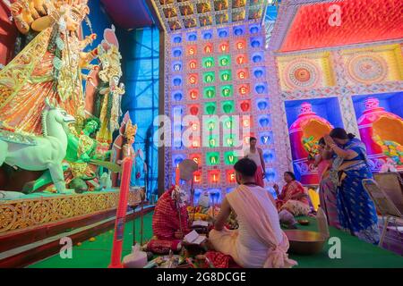 Howrah, Bengale-Occidental, Inde - 5 octobre 2019 : Hindou Bengali sari vêtu de femmes faisant pranam, priant à la déesse Durga à l'intérieur de pandal, sous la direction fro Banque D'Images