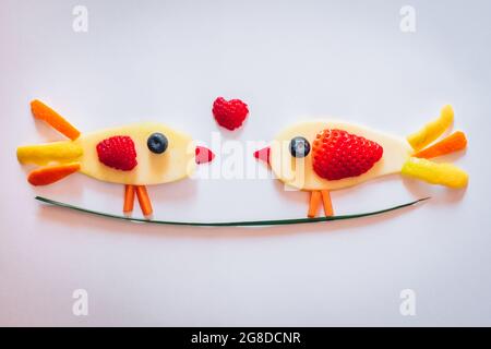deux oiseaux faits de mangue, fraise, raisin, myrtille, isolés sur fond blanc, amour valentine concept Banque D'Images