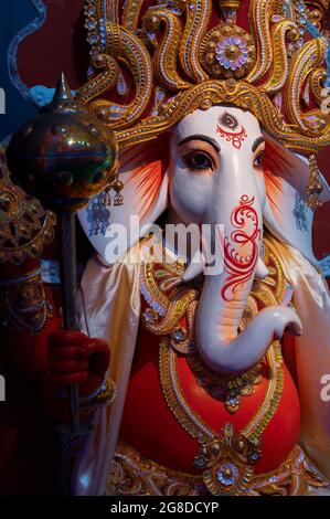 Visage du Seigneur Ganesha à la Durga Puja pandal, festival de Durga Puja la nuit. Tourné sous une lumière colorée à Howrah, Bengale-Occidental, Inde. Banque D'Images