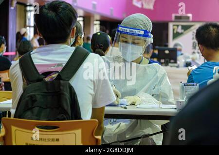 Taipei, Taïwan. 19 juillet 2021. Un travailleur médical portant une combinaison d'équipement de protection individuelle (EPI) enregistre un homme pour le vaccin avant l'alerte COVID-19 de niveau 3 à Taipei. Crédit : SOPA Images Limited/Alamy Live News Banque D'Images