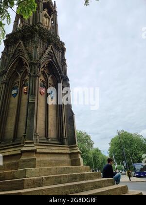 Les touristes et les étudiants s'assoient et se détendent sur les marches du Mémorial des martyrs, un monument en pierre situé à l'intersection de St Giles, de la rue Magdalen et de la rue Beaumont, à l'ouest du Balliol College, Oxford, Angleterre. Il commémore les Martyrs d'Oxford du XVIe siècle. Conçu par George Gilbert Scott, le monument a été achevé en 1843 après deux ans de travail, après avoir remplacé « une vieille maison pittoresque mais chancelante ». Royaume-Uni. Banque D'Images