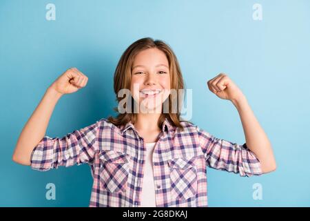 Photo d'une personne insouciante bras flexion biceps sourire crasseux porter un tissu écossais isolé sur fond bleu Banque D'Images