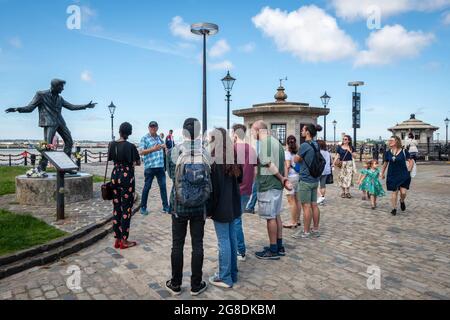 Les sites du patrimoine de Liverpool. Touristes près de la statue de Billy Fury entre Pier Head et Albert Dock. Banque D'Images