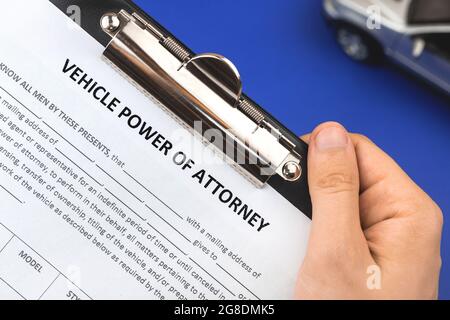 Man Hold vechile formulaire de demande de procuration. Bureau et presse-papiers avec accord. Vue de dessus Banque D'Images