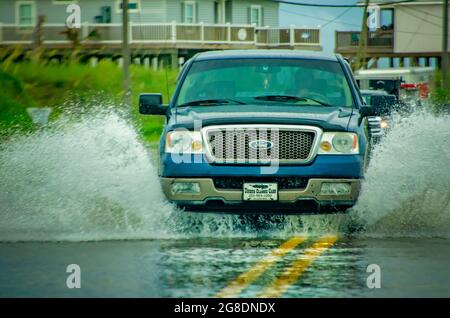 Les conducteurs naviguent sur des routes inondées après de fortes pluies, le 7 juillet 2021, à Dauphin Island, Alabama. Banque D'Images