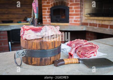 Viande crue sur un pont, un couteau coincé dans la viande. Viande fraîche sur une planche à découper. Gros plan. Banque D'Images