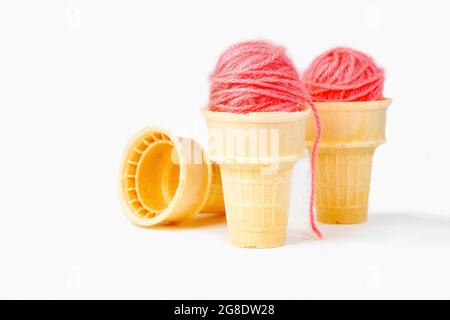 Boules de fils roses en cônes de crème glacée isolés sur fond blanc Banque D'Images