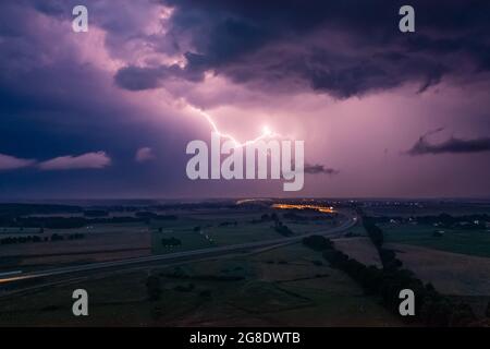 Tempête intense sur les routes et champs express, nuages sombres et foudre le soir Banque D'Images