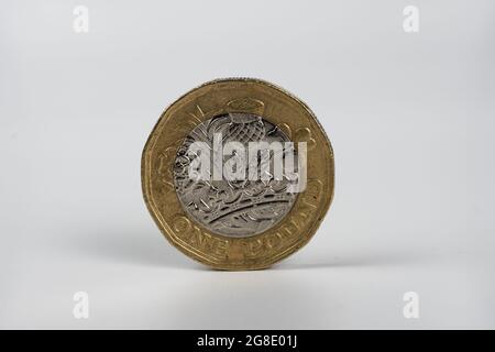 Photo macro britannique d'une livre. La pièce de monnaie résiste aux signes de circulation, à l'état usé. Isolé sur blanc. Banque D'Images