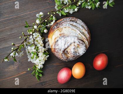 Pâques encore la vie. Délicieux petit pain sucré, œufs de pâques et fleurs de printemps sur fond de table en bois. Pose à plat. Banque D'Images