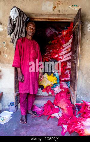 Commerçant avant son magasin plein de cuir coloré, Kano, état de Kano, Nigeria Banque D'Images