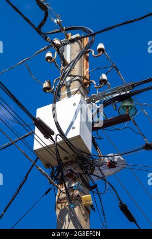 Fils et boîtes électriques avec équipement électrique sur un poteau en béton. Banque D'Images