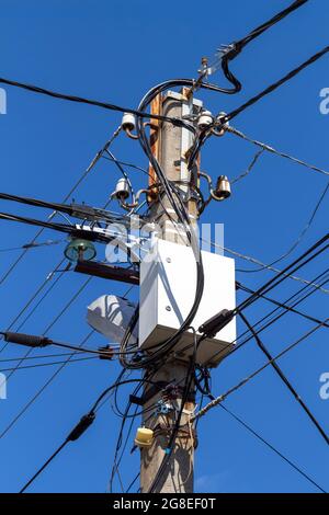 Fils et boîtes électriques avec équipement électrique sur un poteau en béton. Banque D'Images