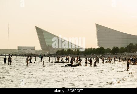 Silhouettes de personnes se baignant dans le golfe finlandais le soir, à la plage du Parc du 300e anniversaire de St Petersbourg, Russie Banque D'Images