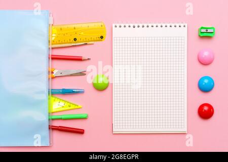 Carnet scolaire et divers fournitures de bureau. Concept de retour à l'école sur fond rose vif Banque D'Images