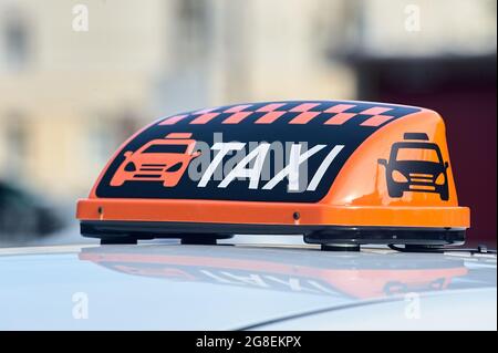 un panneau de taxi orange se trouve sur le toit de la voiture Banque D'Images