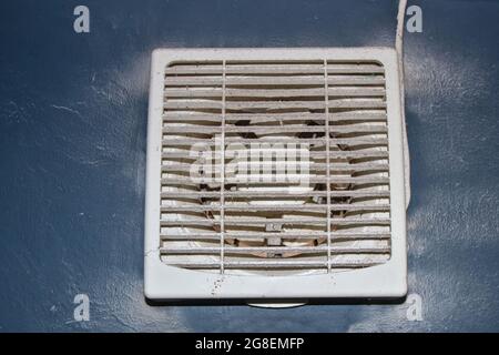 Le ventilateur d'évacuation de la salle de bains est sale, sale, laissant beaucoup de poussière et de poudre sur les lames et les masques de sécurité. Banque D'Images