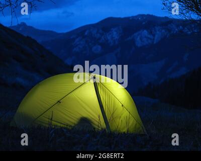 Camping de nuit haut dans les montagnes. Lumière dans les tentes. Excursion de plusieurs jours Banque D'Images