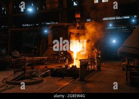 Versement de métal liquide fondu dans le four. Procédé de moulage de l'acier dans la fonderie. Industrie lourde de fabrication métallurgique. Banque D'Images