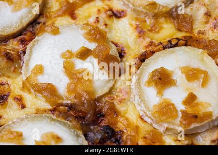 Gros plan de pizza garnie de fromage de chèvre et d'oignon caramélisé. Photo macro de produits délicieux. Banque D'Images