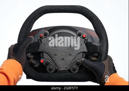 Les mains de Racer en gants tiennent le volant noir isolé sur fond blanc de studio Banque D'Images