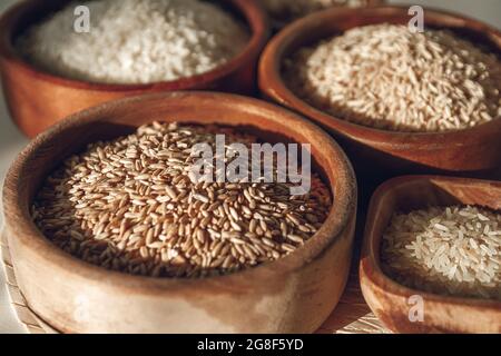 Ensemble de différents types de riz et de céréales dans des bols en bois Banque D'Images