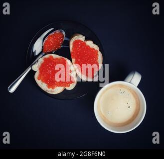 Tasse à café, sandwichs avec caviar rouge et cuillère. Pose à plat. Banque D'Images