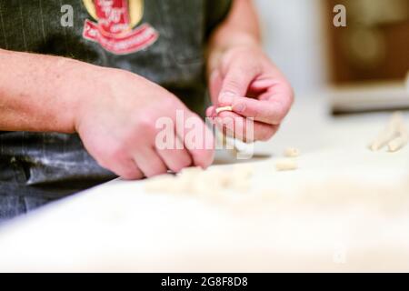 Femme caucasienne adulte préparant des pisarei, pâtes traditionnelles extrudées italiennes de Piacenza, Italie Banque D'Images