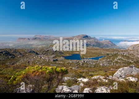 Vue panoramique depuis le sommet de Table Mountain jusqu'au réservoir Woodhead et à Hout Bay, au Cap, en Afrique du Sud le matin contre un ciel bleu Banque D'Images