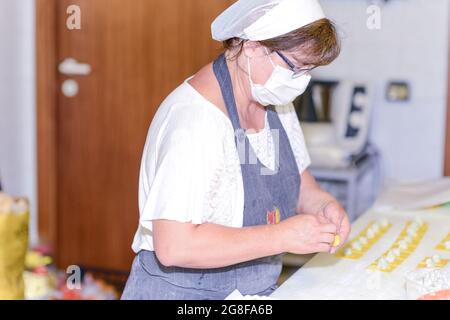 PIACENZA, ITALIE - 17 juillet 2021: Femme qui fait des tortelli , pâtes italiennes farcies traditionnelles Banque D'Images