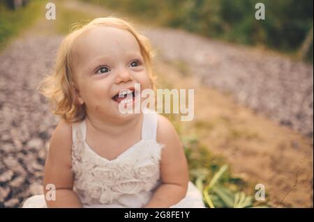 Petite Petite Petite Petite Fille Blonde Mignon Enfant Avec Boucles En Robe Blanche Et Avec La Boue Sur Son Visage Se Trouve Sur Le Sol Dans La Rue A L Exterieur En Ete Petite Petite Petite Petite Fille Blonde Mignon Enfant Avec Boucles En Robe Blanche Et Avec La Boue Sur Son Visage Se Trouve Sur Le Sol Dans La Rue A L Exterieur En Ete