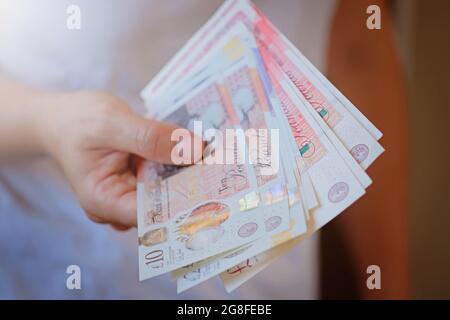 Nouveau plastique dix et vingt Livre de note livre sterling dans les mains de femme. Concept de crise et d'épargne. Le siem de la finance britannique Banque D'Images