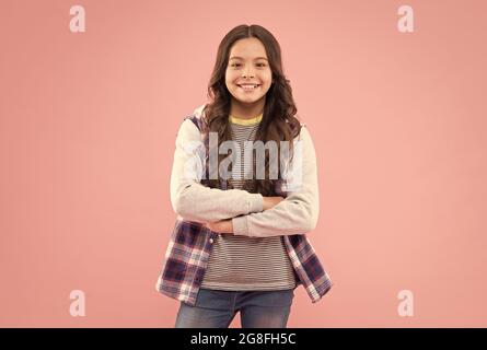 Elle est vraiment mignonne. Un enfant heureux sourit sur fond rose. Look de beauté. Petite fille enfant dans un style décontracté. Tendance à la mode. Style tendance. Garde d'enfants et Banque D'Images