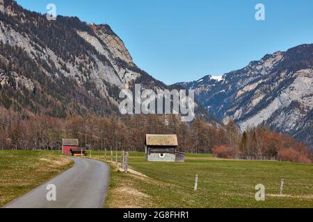 Des granges rurales dans la vallée supérieure du Tamintal près de Vaettis avec la station supérieure de télécabine de Feuscha sur Vaettnerberg Banque D'Images