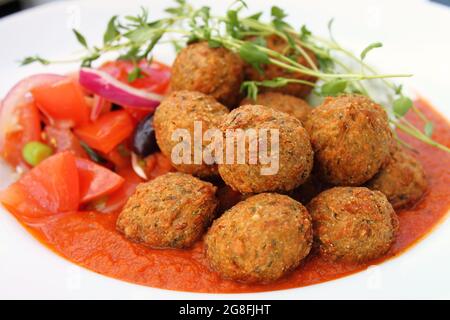 Boulettes de falafel végétariennes avec sauce tomate et salade Riata au concombre, gros plan. Banque D'Images