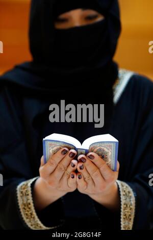 Femme musulmane lisant le Noble Coran, Émirats arabes Unis, Moyen-Orient Banque D'Images