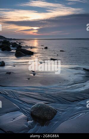 Coucher de soleil sur la côte de Solway Firth, avec des reflets sur le sable et les rochers pendant une marée descendante. Près d'Allonby, nord-ouest de Cumbria, Angleterre Banque D'Images