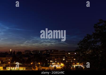 Nuage de Noctilucent (NLC, nuages de nuit) sur le projet de logement et l'église dans la soirée. Phénomènes ressemblant à un nuage dans la mésosphère. Ce sont les nuages les plus élevés dans E Banque D'Images