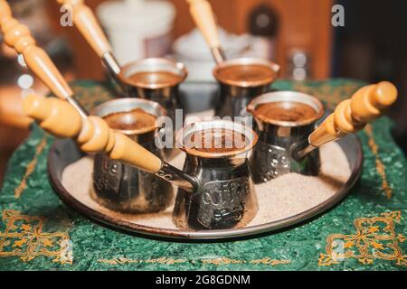 Café turc infusé sur du sable dans la cezve. Café oriental. Banque D'Images