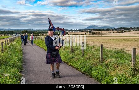 Un joueur de cornemuse mène une procession le long du site du champ de bataille lors de la commémoration de Pinkie Cleugh, East Lothian, Écosse, Royaume-Uni Banque D'Images