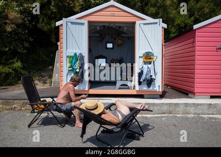 Folkestone, Royaume-Uni. 20 juillet 2021. Les gens à leur cabane de plage, partie de 'No 1054 arpeggio', 2021, par Rana Begum - un arrangement de couleurs spécial donné à 120 cabines de plage. Aperçu de l'exposition Plot, cinquième triennale de Folkestone créatif. Folkestone n'a pas de galerie d'art subventionnée publiquement, de sorte que des artistes renommés ont été invités à utiliser les espaces publics pour créer de nouvelles œuvres d'art dans la ville balnéaire. Plus de 20 œuvres sont exposées du 22 juillet au 2 novembre 2021. Credit: Stephen Chung / Alamy Live News Banque D'Images