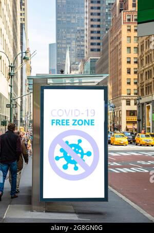 Panneau de zone libre Covid. COVID 19 ÉTIQUETTE DE texte DE ZONE LIBRE sur le panneau d'affichage de l'arrêt d'autobus, arrière-plan du trottoir de la rue du centre-ville. Zones désinfectées, vaccinées uniquement Banque D'Images