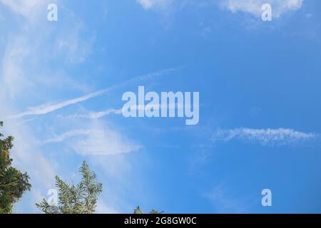 Jet plane contrails ou les pistes de type fumée de vapeur d'air vu dans le ciel bleu clair de la maison. Avion dans le ciel Banque D'Images