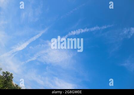 Jet plane contrails ou les pistes de type fumée de vapeur d'air vu dans le ciel bleu clair de la maison. Avion dans le ciel Banque D'Images