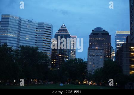 Montréal, QC, Canada - 7-15-2021: Une ligne d'horizon du centre-ville, rue Sherbrooke à l'heure bleue du crépuscule. Le premier plan est le champ inférieur de l'université McGill Banque D'Images