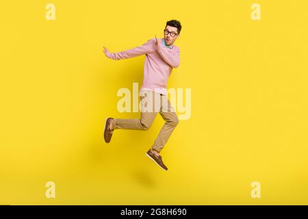 Photo pleine grandeur de jeune choqué surpris surpris homme courant dans l'air des problèmes isolés sur fond jaune Banque D'Images